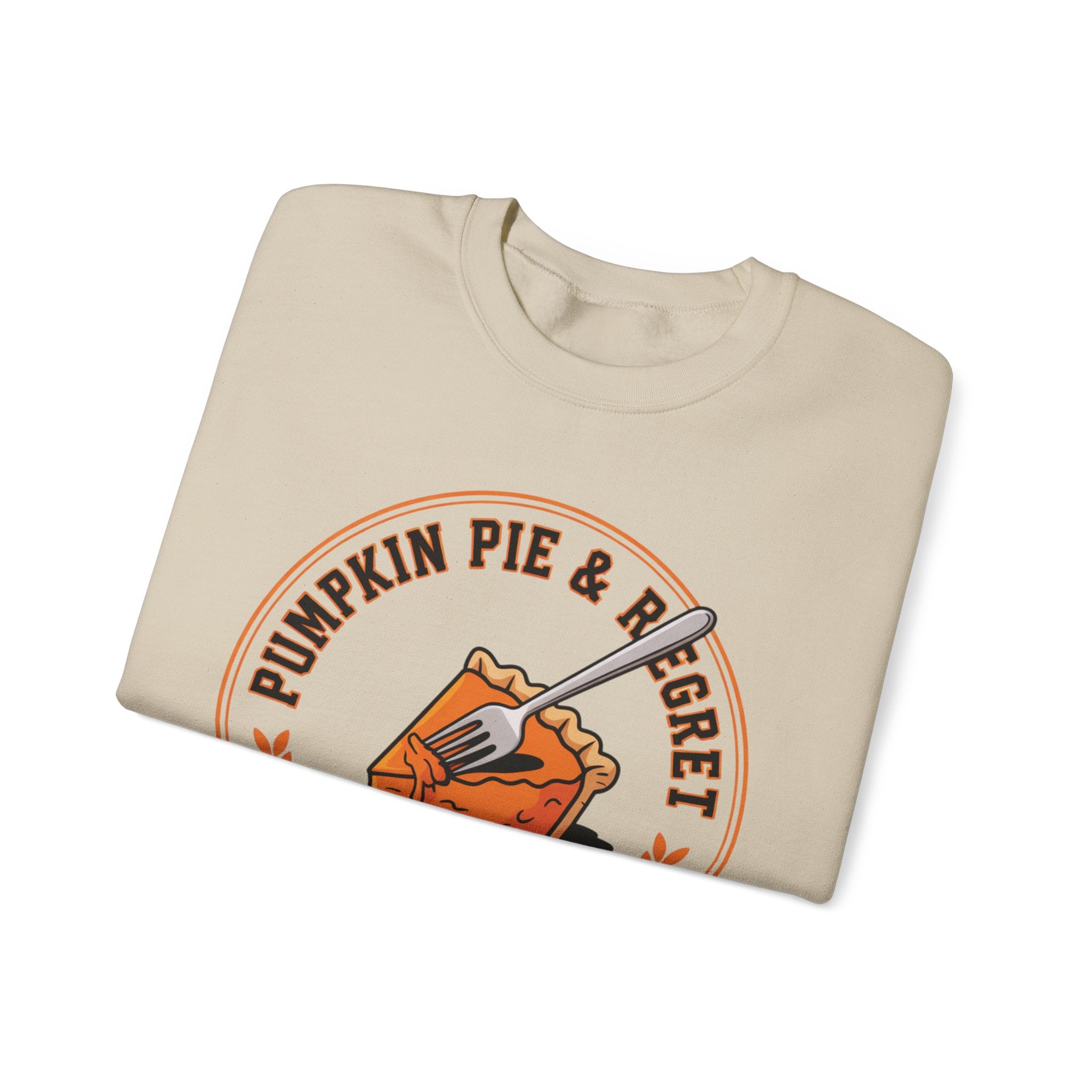 Folded Sand sweatshirt with 'Pumpkin Pie & Regret' graphic on a white background